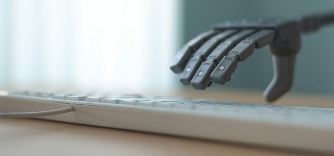 mākslīgais intelekts - datora klaviatūra, kurai virzās klāt robota roka