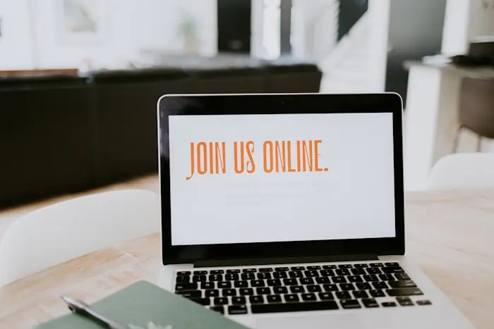 Laua peal olev sülearvuti, mille ekraanil on kiri „Join Us Online”